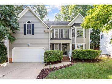 Charming gray two-story home boasts a manicured lawn, attached garage, and inviting front porch at 9504 Anson Grove Lane Ln, Raleigh, NC 27615