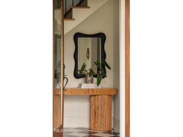 Charming entryway featuring a unique console table, decorative mirror, and stylish black and white tile flooring at 1113 Mordecai Dr, Raleigh, NC 27604