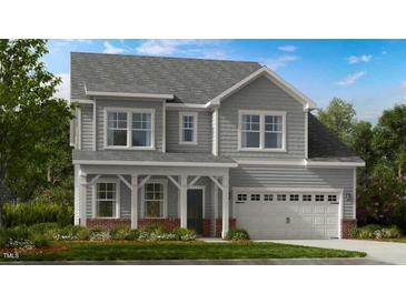 Charming two-story home with a welcoming covered porch and attached two-car garage at 121 Seagraves Creek Ln, Holly Springs, NC 27540