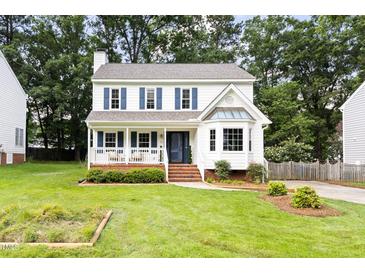 Charming two-story home with blue shutters, inviting front porch, manicured lawn, and mature trees at 16 Cedar Hill Dr, Durham, NC 27713