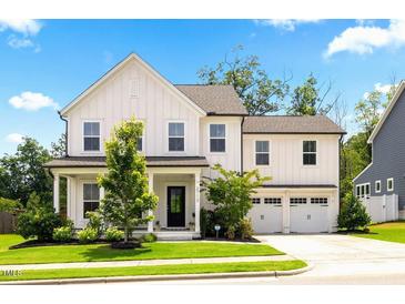 Charming two-story home with a manicured lawn, a covered front porch, and an attached two-car garage at 2713 Jazzy St, New Hill, NC 27562