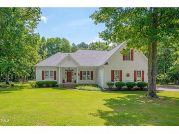 Charming white two-story home featuring a well-manicured lawn, mature trees, and inviting curb appeal at 300 Williamston Ridge Dr, Youngsville, NC 27596
