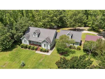 Charming two-story home featuring a bay window, dormers, and lush, mature landscaping at 3113 Golden Nugget Dr, Clayton, NC 27520