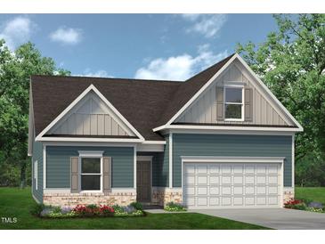 Charming home with blue siding, brick accents, and a two-car garage nestled among lush greenery at 360 Ambassador Dr, Clayton, NC 27520