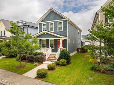 Charming two-story home with a well-manicured lawn, landscaped bushes and a welcoming red front door at 426 Granite Mill Blvd, Chapel Hill, NC 27516