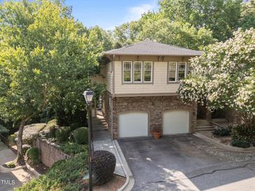 Charming home featuring a stone base, two-car garage, and beautiful landscaping at 4511 Crab Creek Dr # 101, Raleigh, NC 27612