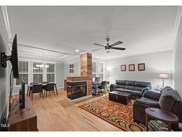 Spacious living room featuring a fireplace and adjacent dining area at 4511 Crab Creek Dr # 101, Raleigh, NC 27612