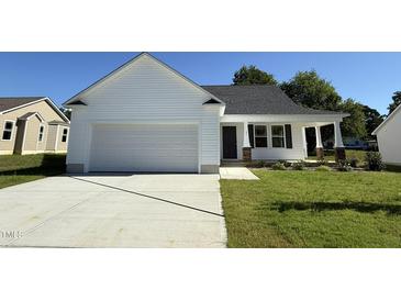 Charming single-story home with a two-car garage, inviting front porch, and well-maintained lawn at 91 Oakfield Trace Dr, Four Oaks, NC 27524