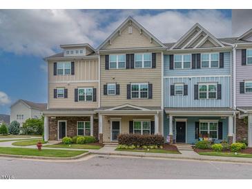Charming exterior of townhomes with inviting front porches, colorful facades, and manicured landscaping at 996 Tender Dr, Apex, NC 27502