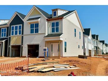 New construction home with white siding, large windows, and a front-entry two-car garage at 107 Ripple Way # 209, Clayton, NC 27520