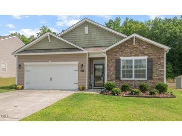 Charming single-story home featuring stone and tan siding with a well-manicured front lawn at 2730 Spring Valley Dr, Creedmoor, NC 27522