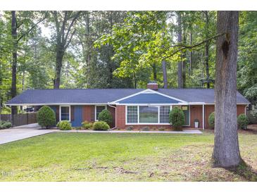Charming single-story brick home with lush green lawn, landscaping, and inviting curb appeal at 2801 E Shoreham St, Durham, NC 27707