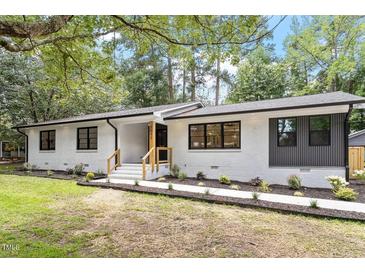 Beautifully renovated single-story home with painted white brick and professionally landscaped front yard at 3032 Dixon Rd, Durham, NC 27707