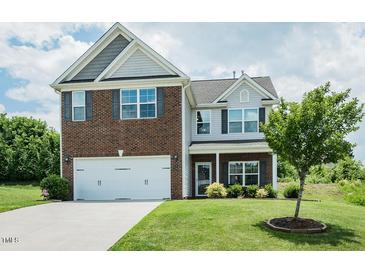 Charming two-story home featuring a brick and vinyl facade with a two car garage and well maintained lawn at 514 Alamanni Ct, Graham, NC 27253