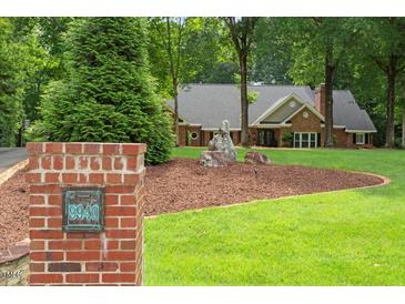 Charming brick home with landscaped front yard and mature trees at 9940 Koupela Dr, Raleigh, NC 27614
