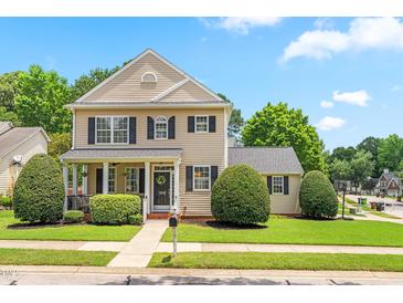 Charming two-story home with a manicured lawn, neat hedges, and classic architectural details at 100 Fountain Springs Rd, Holly Springs, NC 27540