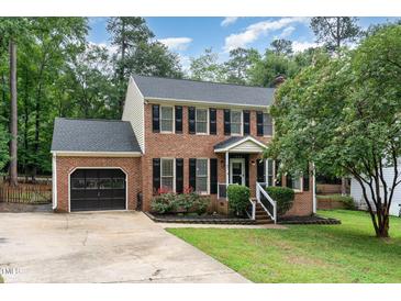 Charming brick two-story home with black shutters, landscaped front yard, and attached garage at 1006 Mingo Pl, Knightdale, NC 27545