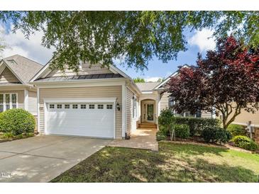 Charming home exterior featuring a two-car garage and well-maintained landscaping at 1034 Ventnor Pl, Cary, NC 27519