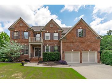 Charming two-story brick home with a well-manicured lawn, two-car garage, and classic architectural details at 111 Revere Forest Ct, Cary, NC 27519