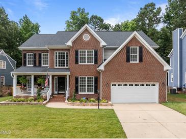 Charming brick home featuring a manicured lawn and an attached two-car garage at 114 Council Gap Ct, Cary, NC 27513