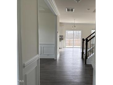 Inviting hallway leading to the living spaces, enhanced by hardwood floors and stylish wall trim at 185 Bourne Dr, Franklinton, NC 27525