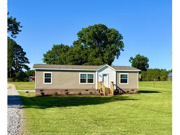 Inviting single-story home with charming front porch, and a lush green lawn at 2232 Tarboro Road Rd, Youngsville, NC 27596