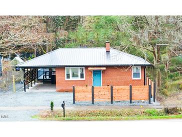Charming brick home with a vibrant blue front door and a modern metal roof at 2907 University Dr, Durham, NC 27707