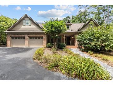 Charming brick home featuring a two-car garage, manicured landscaping, and a welcoming front entrance at 3600 Trail 23 St, Durham, NC 27707