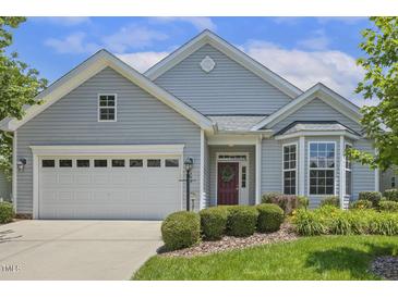 Charming single-story home features a manicured lawn, two-car garage, and a welcoming red front door with a wreath at 400 Indian Elm Ln, Cary, NC 27519