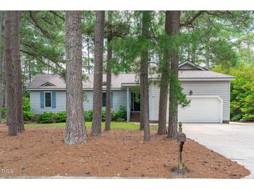 Charming single-story home with a well-maintained lawn, light grey siding, and a two-car garage surrounded by mature trees at 502 Hillcrest Rd, Apex, NC 27502