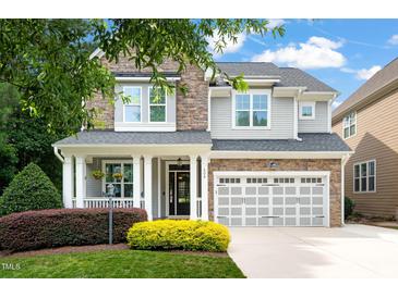 Charming two-story home with stone and siding, a welcoming porch, and a two-car garage at 508 Morning Oaks Dr, Holly Springs, NC 27540