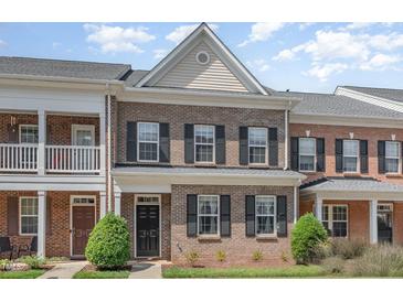 Charming brick townhome featuring a classic design and well-maintained landscaping at 513 Dragby Ln, Raleigh, NC 27603