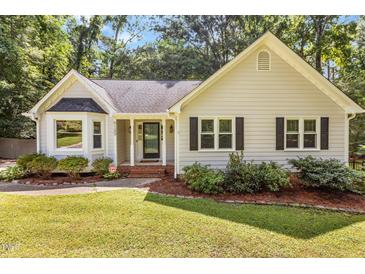 Charming home featuring manicured lawn, mature landscaping, and inviting front porch at 6129 Krandon Dr, Raleigh, NC 27603