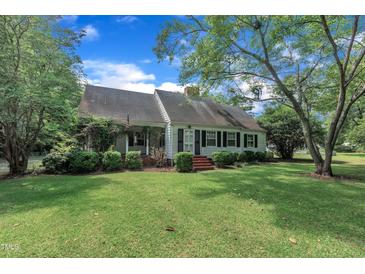 Charming single-story home with manicured lawn, lush landscaping, and inviting front porch at 705 Wilsons Mills Rd, Smithfield, NC 27577