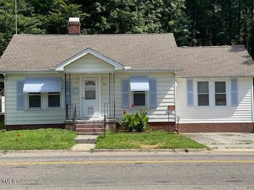 Charming one-story home with a well-manicured lawn, light blue shutters, and inviting front entrance at 906 Camden Ave, Durham, NC 27701