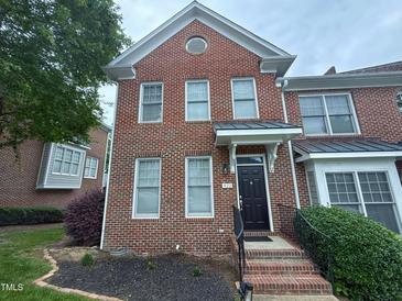 Charming brick townhome featuring a black front door and well-maintained landscaping at 922 Edgewater Cir, Chapel Hill, NC 27516