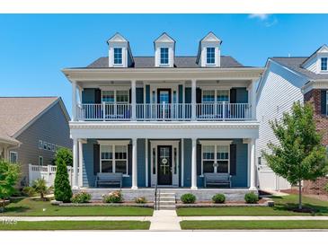 Beautiful two-story home with a covered front porch and well-manicured lawn on a sunny day at 1108 Lowland St, Apex, NC 27523