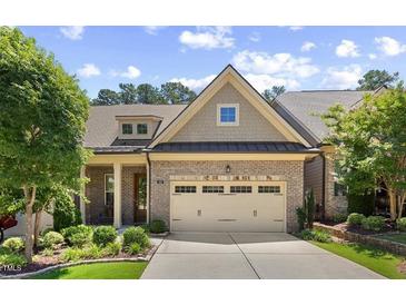 Charming brick home showcasing a well-manicured lawn and attached two car garage at 122 Glenpark Pl, Cary, NC 27511