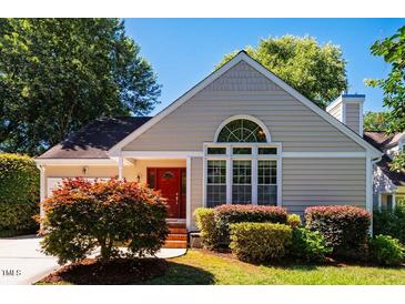 Charming single-story home featuring a red front door, well-manicured landscaping, and a bright, inviting facade at 13 Boxwood Dr, Durham, NC 27713