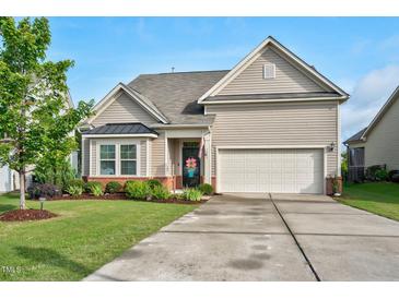 Charming home with a well-manicured lawn and attached two car garage at 1409 Sage Tree Dr, Zebulon, NC 27597