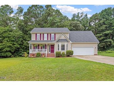 Inviting two-story home with a lush green lawn and attached two car garage at 161 Jacob St, Holly Springs, NC 27540