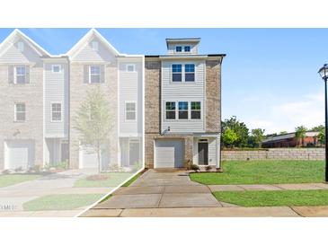 Charming new construction townhome featuring a brick and siding facade and an attached one car garage at 1921 Fishamble St # 13, Fuquay Varina, NC 27526