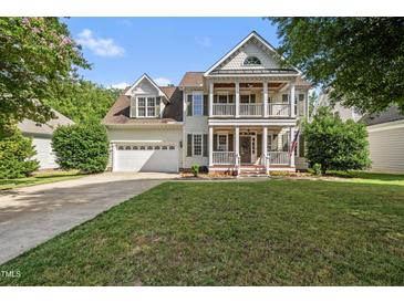 Charming two-story home featuring a welcoming front porch, well-manicured lawn, and attached two car garage at 2027 River Grove Ln, Knightdale, NC 27545