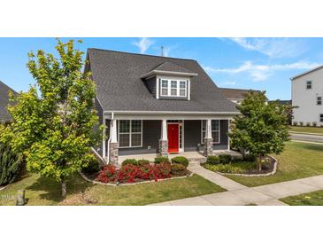 Charming home exterior with a red front door, manicured landscaping, and inviting front porch at 2057 Big Falls Dr, Wendell, NC 27591