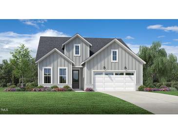 Charming two-story home showcasing a well-manicured lawn and a welcoming two-car garage at 2404 Flemingstone Ln # 51, Raleigh, NC 27610
