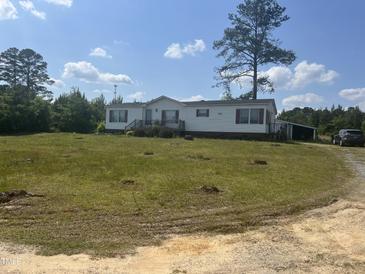 Charming single-story home with white siding and a spacious front yard on a sunny day at 248-A Gilbert Rd, Benson, NC 27504