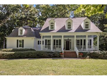 Charming home featuring a spacious front porch,dormer windows,neat landscaping and a well-maintained lawn at 5216 Woods End Rd, Hillsborough, NC 27278
