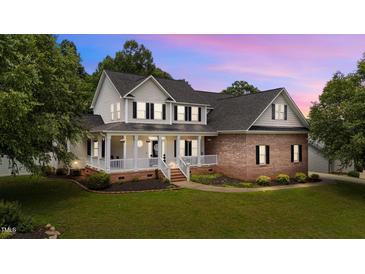 Charming two-story home showcasing a brick and siding facade, a covered porch, and a well-manicured lawn at 81 Northcliff Ct, Clayton, NC 27527