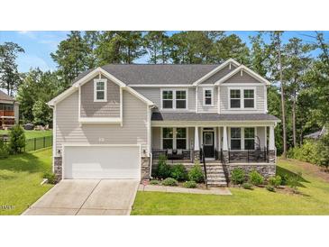 Charming two-story home with a well-manicured lawn, inviting front porch, and attached two-car garage at 103 Foothill Ct, Sanford, NC 27330