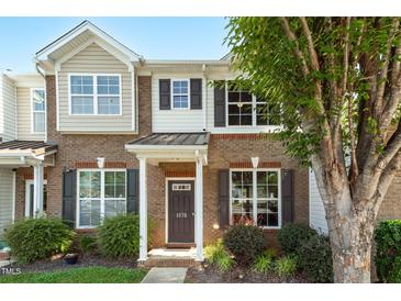 Charming brick townhome with a covered entryway and well-manicured landscaping at 1076 Kelso Ln, Burlington, NC 27215